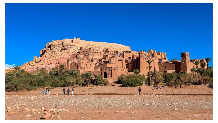 Ksar de Ait Ben Haddou entre palmeras bajo un cielo azul