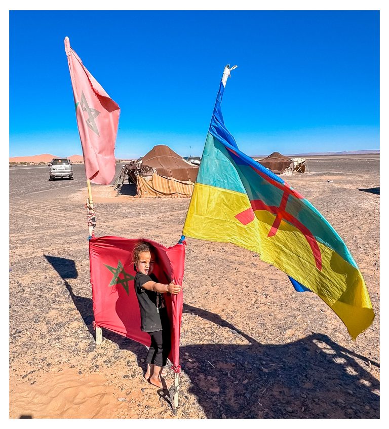 Persona con banderas amazigh en el desierto cerca de Merzouga