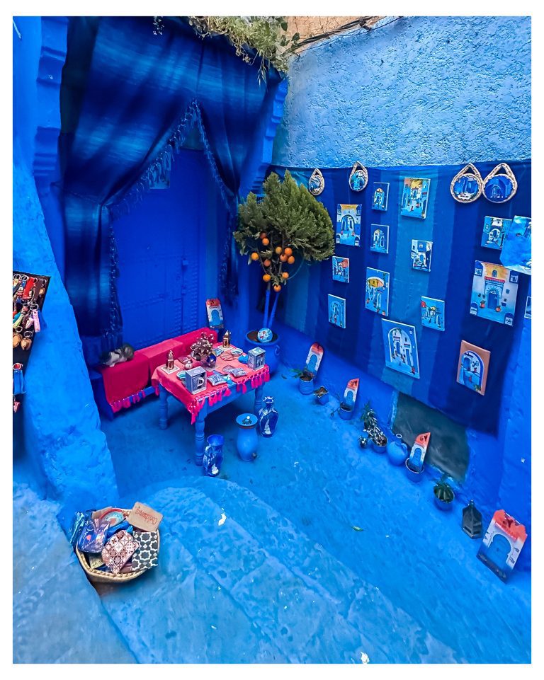 Rincón pintado de azul en la medina de Chefchaouen con cojines y alfombras