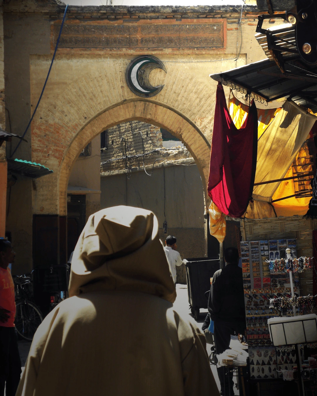 6 Figura con capucha caminando bajo un arco en la medina de Marrakech