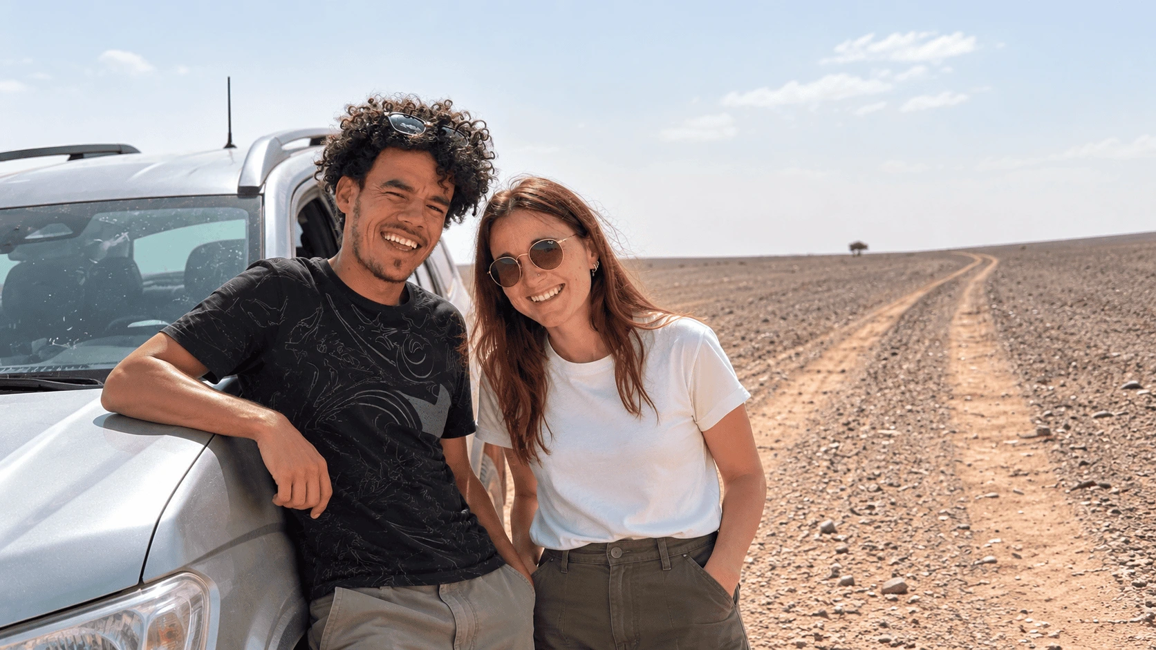 Moha y Neus, fundadores de Marruecos Nómada, junto a un 4x4 en una pista del desierto