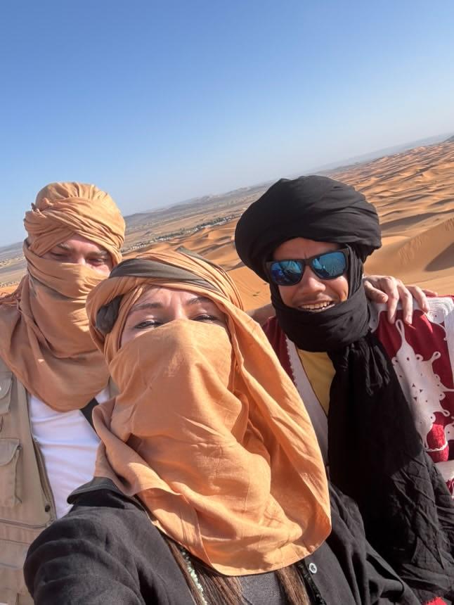 Moha con viajeros en Erg Chebbi Moha con dos viajeros, con turbantes, en lo alto de una duna de Erg Chebbi